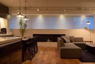 インテリアとしての「火」。既存の狭苦しさを一新し、眺望を活かしつつ、構造の一部を表しにしたラフでおしゃれな空間。キッチン壁はタイル、室内の壁や天井などは構造に直接塗装し、無垢材の床、中古ならではの味わい。煙突が要らないエコなバイオエタノール暖炉を採用。既製品を要所に使い、コストダウン。照明はスポットライト。札幌の高級マンションリフォームの実例をご紹介します。「和室をリビングに取り込んで ワイドビューを楽しむ暮らし」のリフォーム事例です。施工はプラスアルファ。