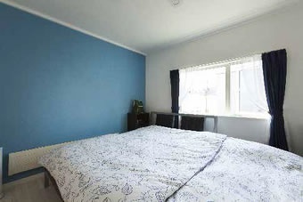 子供部屋の向かい側はご夫妻の寝室。アクセントウォールは落ち着いた色に仕上げています。