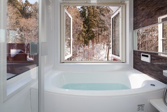 森を身近に感じる特等席のお風呂。渡り廊下には、カウンターを造作して奥さまの書斎コーナー、ダイニングとリビングには床暖房とインテリアにもなる薪ストーブ、お雛さまを飾る場所をリビングの一部に。こだわりの浴室は、森を感じられる大きな両開きの窓。住まう人の想いが形になった戸建てリフォーム事例です。施工は札幌の北王RELIFEリライフ