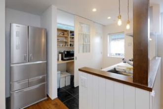 容量たっぷりのキッチン収納は、目隠しできる引き戸仕様。棚上に窓があるので、引き戸を閉めても光が取り入れられます。右隣には食品庫も。