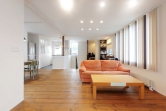 キッチンとリビングを離すことで、家事の音が気にならない間取り。床板はツーバイ材を使用。壁は光を広げる白色で統一しました。近所の視線を気にせずに 心ゆくまで窓外の眺めを楽しむため、2階リビングの家に中古リノベーション。設計も性能も新築を超える出来映え。キッチンとリビングを離して、家事の音が気にならない間取り。床板はツーバイ材。玄関ホールの吹き抜けに面したキッチン、収納は隠しできる引き戸仕様。土足でも使えるシューズクローク、自転車も置ける土間玄関。施工はアルティザン建築工房