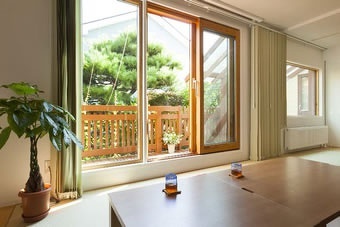 1階茶の間。カップボードやシステムキッチンの背面収納を造作した美しいキッチン、光と風を取り込む茶の間、畳を取り入れたフラットフロアは壁を取り払って2部屋分の広さを確保しました。戸建て二世帯のリフォーム実例です。施工は札幌の北王リライフ。