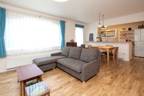 中古リホーム、リノベーション戸建て、一軒家の事例を紹介します。８年前セミオーダーで新築した家は、ダークブラウン系のモダンなデザイン。不満を感じ、自分が好きな手作り家具やナチュラル系のアイテムを置くためリフォーム。玄関ホールはナラ無垢材のフローリング。家具や味わいのある照明ともピッタリ。キッチンの見せる収納。チェッカーガラス。カフェのような家が完成。施工は札幌のアシスト企画。リフォームの施工事例集、施工店探し、費用の相場、築年数なども掲載、リフォームのイメージづくりができるのでこれからリフォームする方向けの