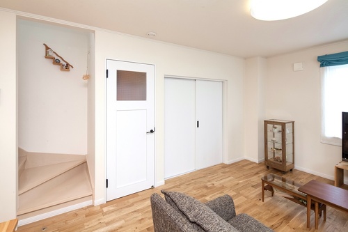 チェッカーガラスのドア。中古リホーム、リノベーション戸建て、一軒家の事例を紹介します。８年前セミオーダーで新築した家は、ダークブラウン系のモダンなデザイン。不満を感じ、自分が好きな手作り家具やナチュラル系のアイテムを置くためリフォーム。玄関ホールはナラ無垢材のフローリング。家具や味わいのある照明ともピッタリ。キッチンの見せる収納。チェッカーガラス。カフェのような家が完成。施工は札幌のアシスト企画。リフォームの施工事例集、施工店探し、費用の相場、築年数なども掲載、リフォームのイメージづくりができるのでこれか