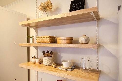 造作のキッチン棚。中古リホーム、リノベーション戸建て、一軒家の事例を紹介します。８年前セミオーダーで新築した家は、ダークブラウン系のモダンなデザイン。不満を感じ、自分が好きな手作り家具やナチュラル系のアイテムを置くためリフォーム。玄関ホールはナラ無垢材のフローリング。家具や味わいのある照明ともピッタリ。キッチンの見せる収納。チェッカーガラス。カフェのような家が完成。施工は札幌のアシスト企画。リフォームの施工事例集、施工店探し、費用の相場、築年数なども掲載、リフォームのイメージづくりができるのでこれからリフ