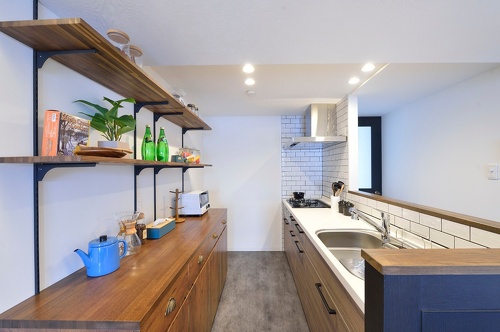 札幌に移住するため、中古マンションを購入しリノベーション。ツーウェイの広い玄関、リビング続きの広いサンルーム。新築にはない味わい。洗面はサブウェイスタイルのタイルに床・カウンター天板・天井は無機質なイメージ。キッチンの背面収納は、ストウブ鍋を置いたときの使い勝手と見た目のバランスを考えて造作。娘の部屋はピンクの壁紙にクリア塗装の無垢フローリング。施工は北王リライフ