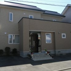 外壁材が傷み、全面を張り替えたリフォーム。意匠性の高い窯業サイディングに変更。緑もよく映え、高級感と暖かさを併せ持つ仕上がり。札幌の戸建てリフォーム実例。施工はイワクラホーム
