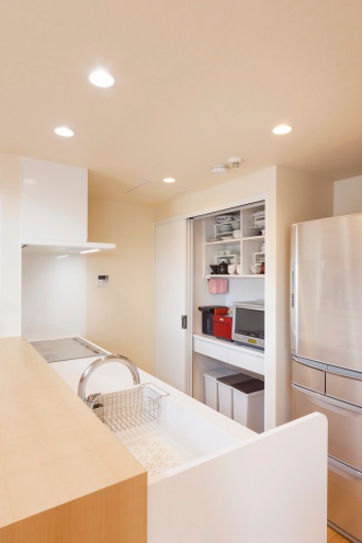 収納抜群のキッチン。もともとハシゴでしか行けなかったキャットウォークへ、２階から廊下でつなぎ日常的に行けるように。マンションなのに回廊型の吹き抜けです。全ての内窓と外周の壁に内側から断熱施工を行い寒さの解消。吹き抜けとキャットウォークのある札幌のマンションリフォーム実例です。施工は株式会社ＳＡＷＡＩ建築工房