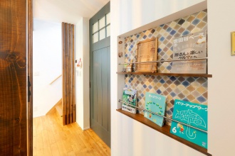 マガジンラック・リビングドア。小学校入学前に好みのテイストに合った落ち着くわが家に札幌リノベーション。吹き抜けのリビングや2階のフリーホールなど、寝室と書斎以外はオープンスペース。暖かい、安心・快適な長期優良住宅。マガジンラックにはタイル調の壁紙。チェッカーガラス入りの引き戸。可動式の収納棚ハンモックを吊るしたフリーホール。施工は株式会社アルティザン建築工房