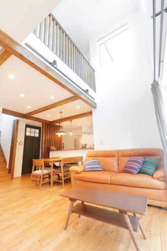 吹き抜け。小学校入学前に好みのテイストに合った落ち着くわが家に札幌リノベーション。吹き抜けのリビングや2階のフリーホールなど、寝室と書斎以外はオープンスペース。暖かい、安心・快適な長期優良住宅。マガジンラックにはタイル調の壁紙。チェッカーガラス入りの引き戸。可動式の収納棚ハンモックを吊るしたフリーホール。施工は株式会社アルティザン建築工房