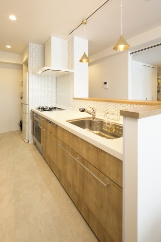 札幌・中古リノベーション・マンション。大空間のLDKにホームシアター機能を導入。配線は天井裏に。収納家具はすべて造作。キッチン腰壁は目隠しを兼ねたバル風のカウンター。広い浴室は戸建て用をカスタマイズして追い炊き機能も追加。扉の木目が美しいシステムキッチンは、ガスオーブンをビルトインしたタイプ。床と壁にヘキサゴン柄を採用した水回り。玄関には土間収納。大容量のウォークインクローゼット。RELIFE＊［リライフ］株式会社北王　リフォーム事業部のマンションリフォーム・リノベーション事例。