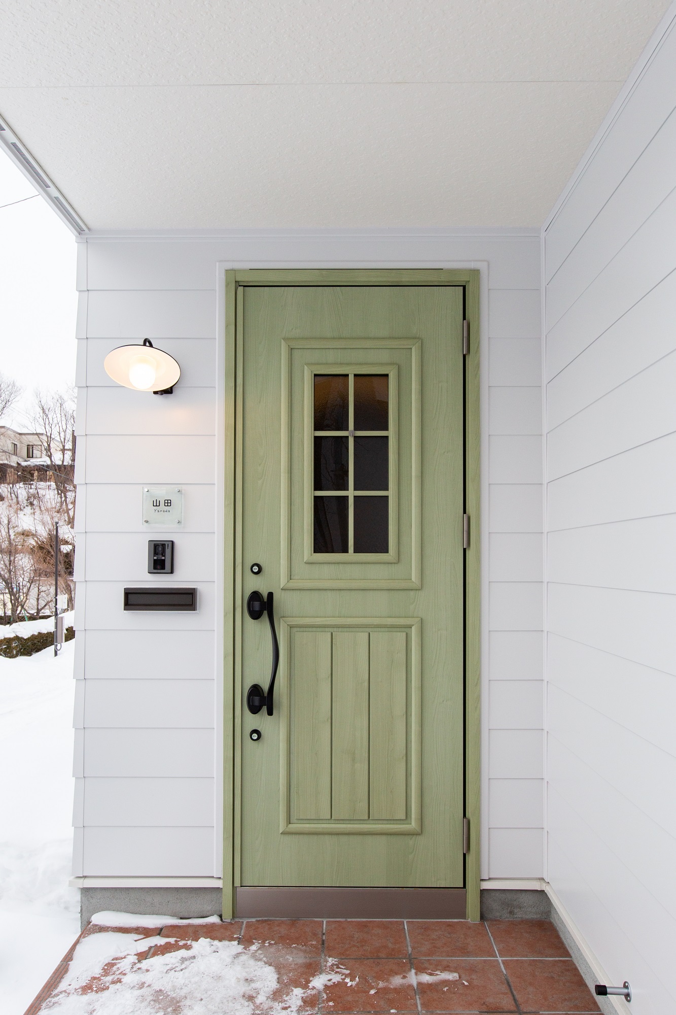 白が清々しいY邸。萌黄色の玄関ドアが静かにアクセントを添えて、瀟洒なイメージ