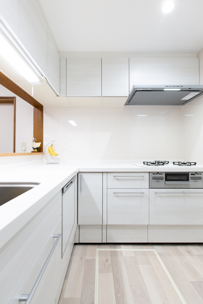 白を基調とした清潔感のあるキッチン。床材も明るめの色を採用しています