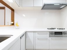 白を基調とした清潔感のあるキッチン。床材も明るめの色を採用しています