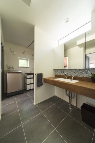 キッチンのフロアタイルを洗面室まで連続させて。かわいらしいタイル壁がシンプルな造作洗面台に表情をつけています