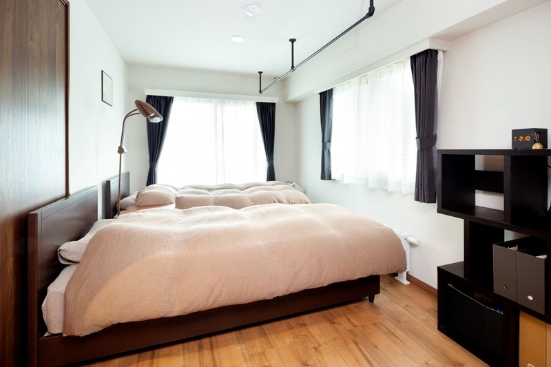 寝室は、ベッドのサイズに合わせてスペースを調整。天井に設置したアイアンのポールには、起床後の布団をかけています。