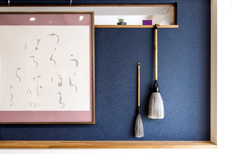 和紙のような趣で味わいのある壁には、大切に使われてきた筆も飾って