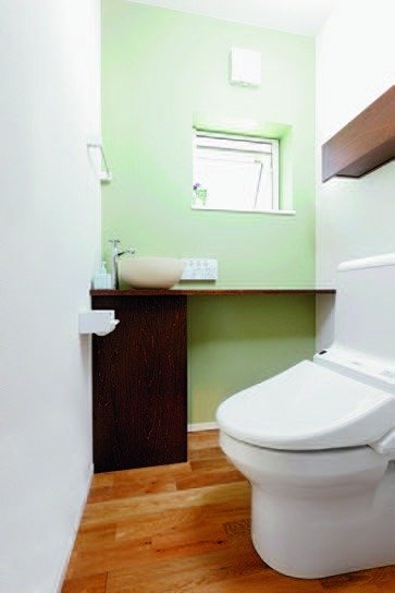 家全体の色使いを統一した薄いグリーンのトイレ