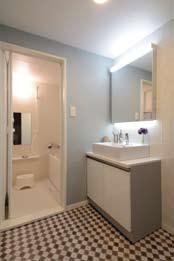 『組み合わせでイメージを一新』モロカンタイル調のフロアに、ブルーグレーの壁、シンプルな一面鏡に置き型の洗面カウンター。リノベの前と広さは変わらずでも内装で全く違う印象に。