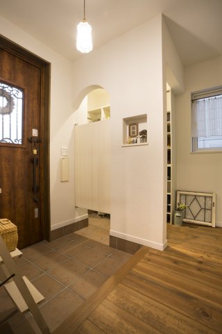 スイングドアをつけた家族用のシューズクロークはアーチ型のデザインを取りいれ、優しい雰囲気に