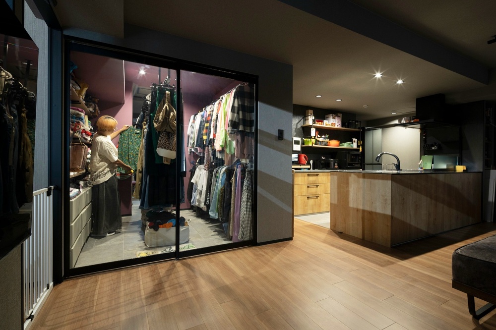 ガラス戸なので中がよく見えるショップのようなウォークインクローゼット。壁はモーブピンクで床は玄関と同じ土間タイルを使用