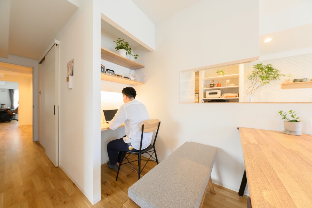 ご主人のワークスペースをダイニングの一角に配置。デスクを広く使えるように、壁に照明を取り付けました