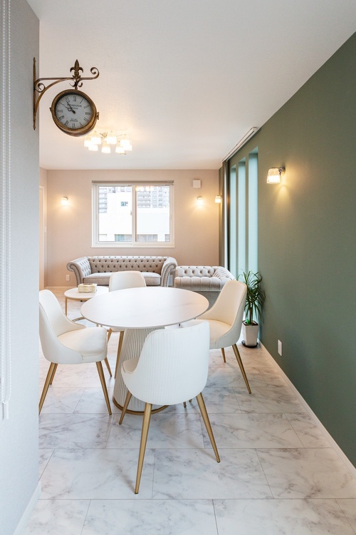 ブルーグリーンの壁と大理石調の床がおしゃれなリビング