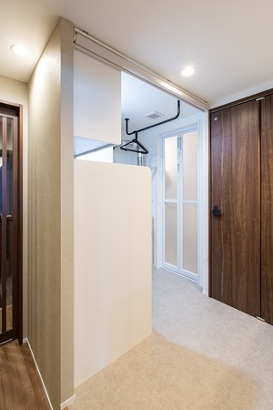 洗濯機を隠す腰壁以外は遮蔽物のない水回り。脱衣時や来客があった時はロールスクリーンを下げて