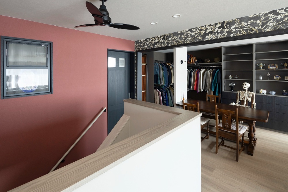 淡い赤と木蓮柄の壁紙で、遊び心のある雰囲気の2階と居候骸骨のジェイク