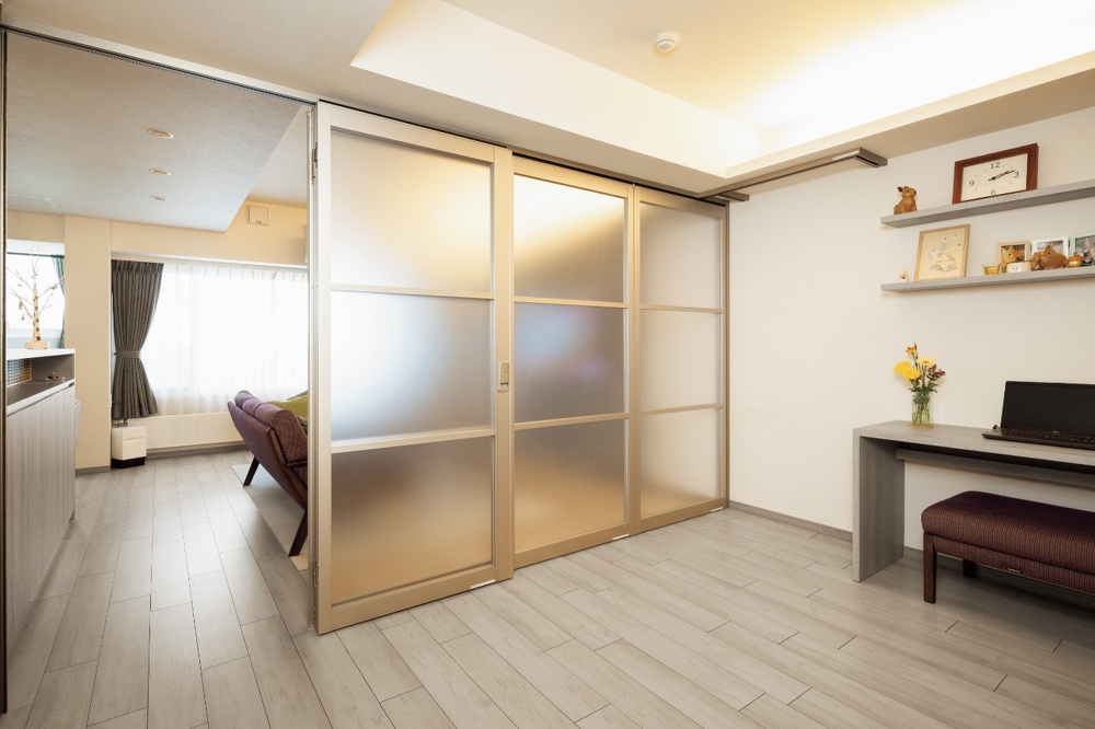 リビングとの仕切りは淡い色のパテーションを使用。光を通す素材なので奥も明るい