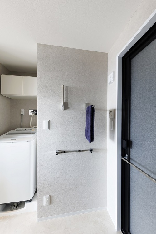 バスルームの扉の枠も黒を選択。壁に付けられた折り畳み式のタオルハンガーもオシャレ