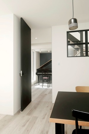 ホールへの扉は天井までのハイドアを採用。ホールとLDKの床を継ぎ目なくつなげて視覚的な広がりを演出しています