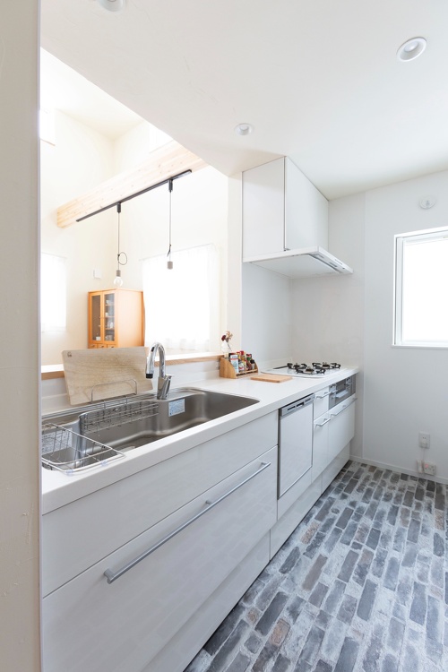 塗り壁の色に合わせてキッチンも白を選択。窓が欲しかった奥さまの要望も叶いました