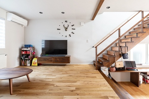 愛用の家具と造作TV台や階段、床が見事に調和。コスト削減でDKの床は突き板に。「汚しやすいので無垢でなくて正解」と奥さま