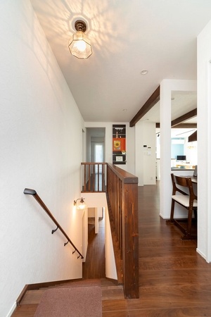 階下のご両親に呼ばれた際、すぐに顔が見えるようにとご主人の案で階段はルーバーに。階段の照明にはご両親の前の家のものを活用しました