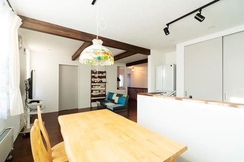 趣味スペース側から見たダイニングとリビング。ダークブラウンの梁が空間の良いアクセントに