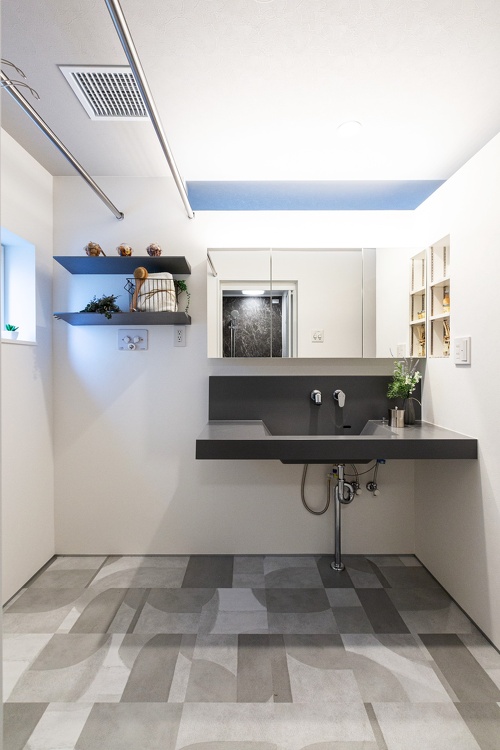 札幌｜戸建て｜中古｜モデルハウス(販売中)｜中古リノベーション施工事例｜アルティザン建築工房_高性能＋創エネ＋省エネで 築41年をZEH住宅に再生！リノベーションモデルハウス_サンワカンパニーの洗面台と棚板を使ったおしゃれな洗面所。床はモノトーンのフロアタイルを使用