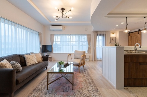 自然光がたっぷり入るリビング。出窓部分のカーテン位置を壁のラインに合わせたことで凹凸が整理され、洗練された印象に