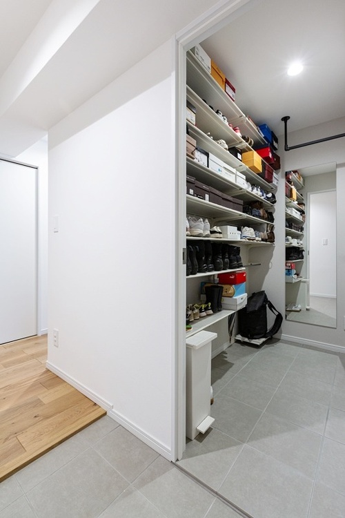 土間のシューズクロークは、中を隠せるドア付き。正面の鏡には全身が映り、外出時のチェックに活躍します