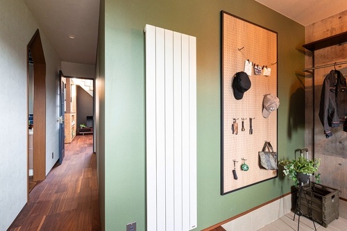 空間ごとにアクセントウォールを取り入れて個性的なインテリアに。家族や来客を出迎える玄関は優しいグリーンをセレクト