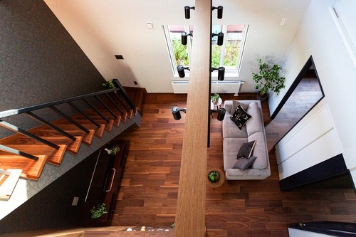 室内バルコニーのような２階ホールから吹き抜けを見下ろして。光に満ちた明るさがさらに広がりのある開放感をもたらします