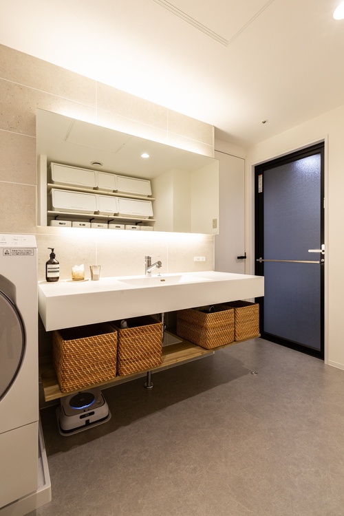 収納かごの高さを事前に図って合わせた洗面台。こちらもミラー部分には間接照明を使用しています