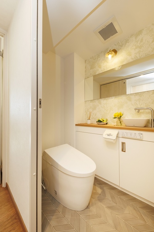 グリーンの壁紙や横長の鏡がおしゃれなトイレ