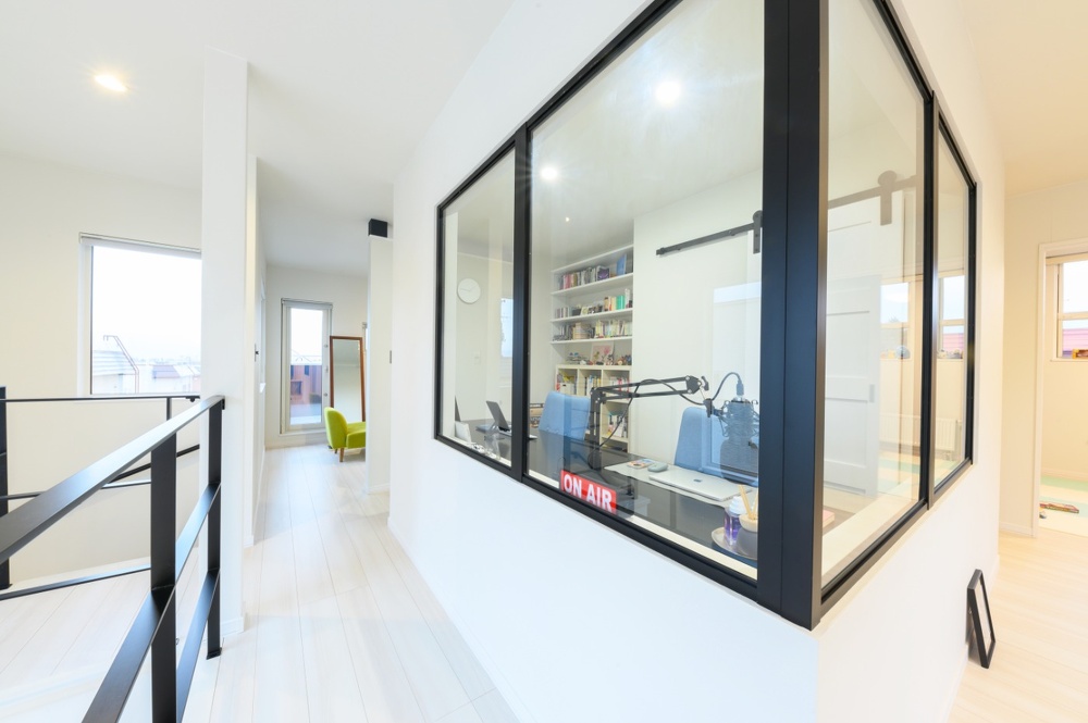 当初からの希望で、ワークルームは黒いアイアンフレームのガラス張りに。吹き抜けに響く音が適度に抑えられ、スキップフロアで遊ぶお子さんの気配を感じつつ仕事に集中できます