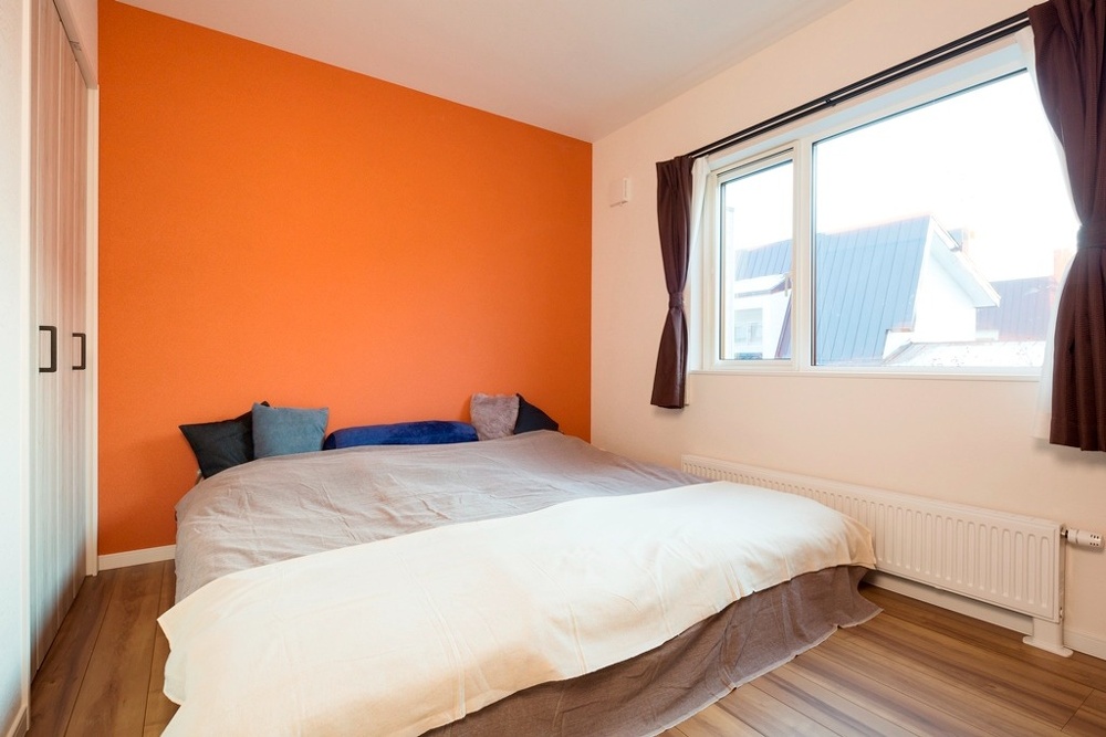 外出時に着るおしゃれ服は寝室のクローゼットに収納。ビビッドカラーのアクセントウォールが明るく楽しげ