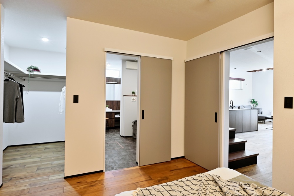 旭川｜戸建て｜モデルハウス(販売中)｜中古リノベーション施工事例｜石山工務店_平屋感覚＋ヴィンテージの『mature model』大人の空間_寝室のベッド側から見て左がウォークインクローゼット、中央が洗面とバス、右がLDK。洗面からはキッチンに抜けられる回遊動線になっています