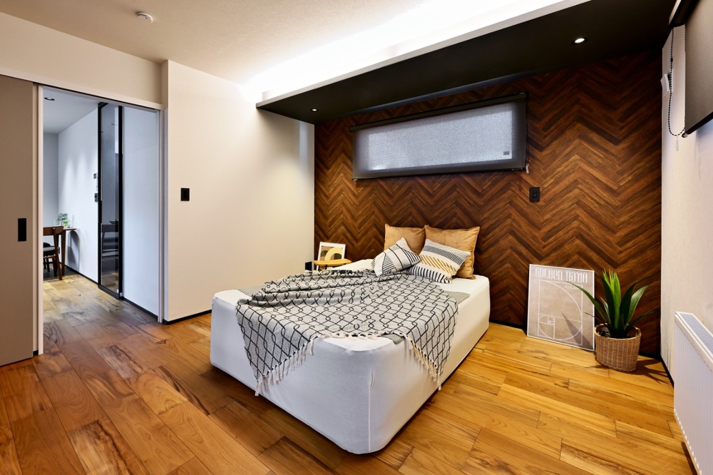 旭川｜戸建て｜モデルハウス(販売中)｜中古リノベーション施工事例｜石山工務店_平屋感覚＋ヴィンテージの『mature model』大人の空間_チークの床とヘリンボーンの壁。間接照明を使った大人の主寝室