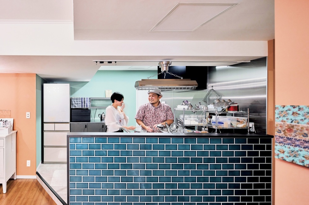 札幌｜中古マンションリノベーション事例｜㈱ライフスタイル｜リノベーション・リフォーム施工会社_お手本はパリのアパルトマンのようなマイホーム_男のキッチン。ステンレスキッチンや4口コンロ、右奥の壁もステンレスに。キッチンの腰板はタイル貼り