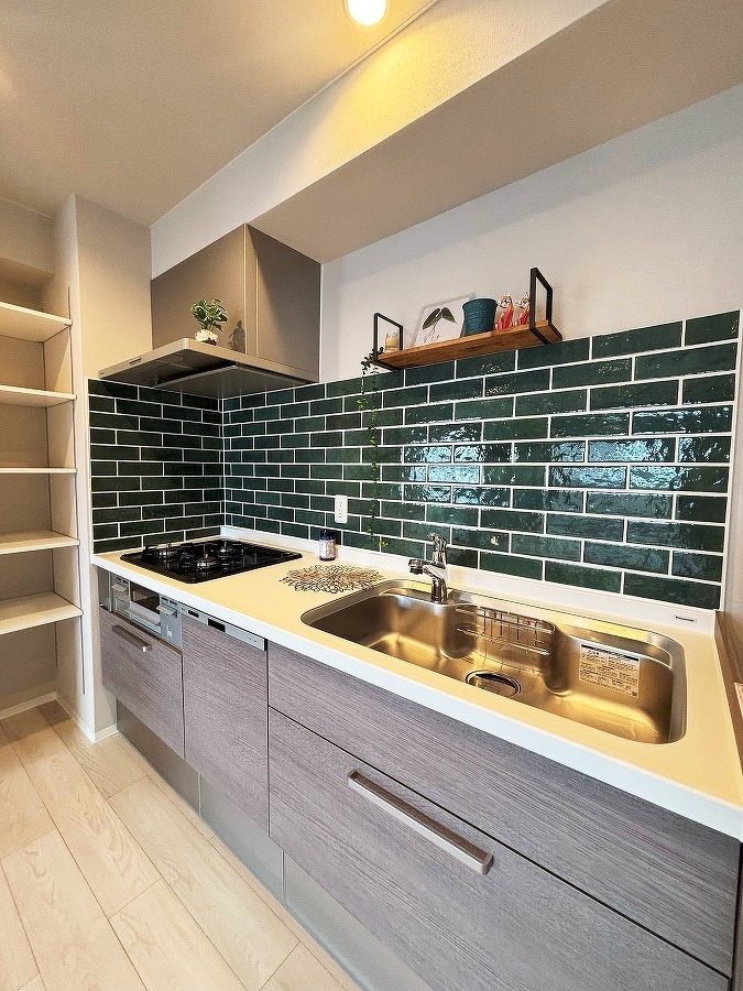 おしゃれなグリーンのタイルを使ったキッチン。横にはオープンパントリーも設置しました