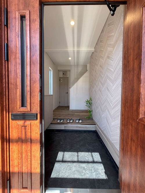 ヘリンボーン柄のクロスがアクセントの明るい玄関